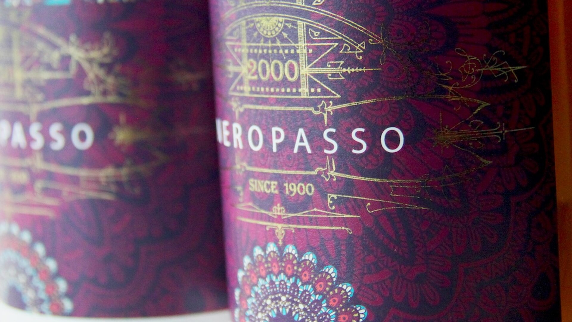 Weinflasche mit Etikett „Neropasso“ in Purpur und Gold mit filigranen Ornamenten und metallischem Glanz.